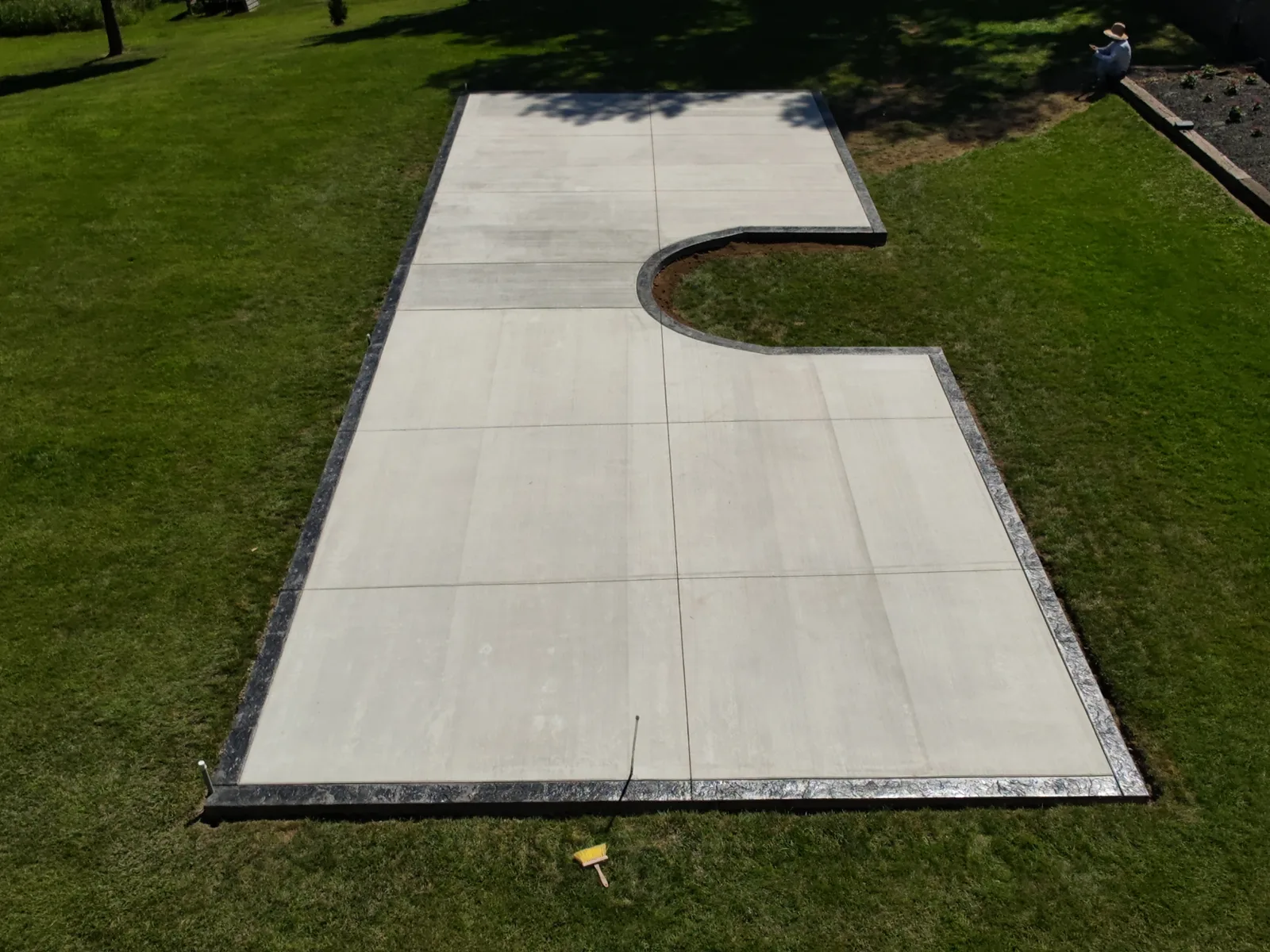 Backyard concrete patio with decorative stamped border and curved edge in Siouxland